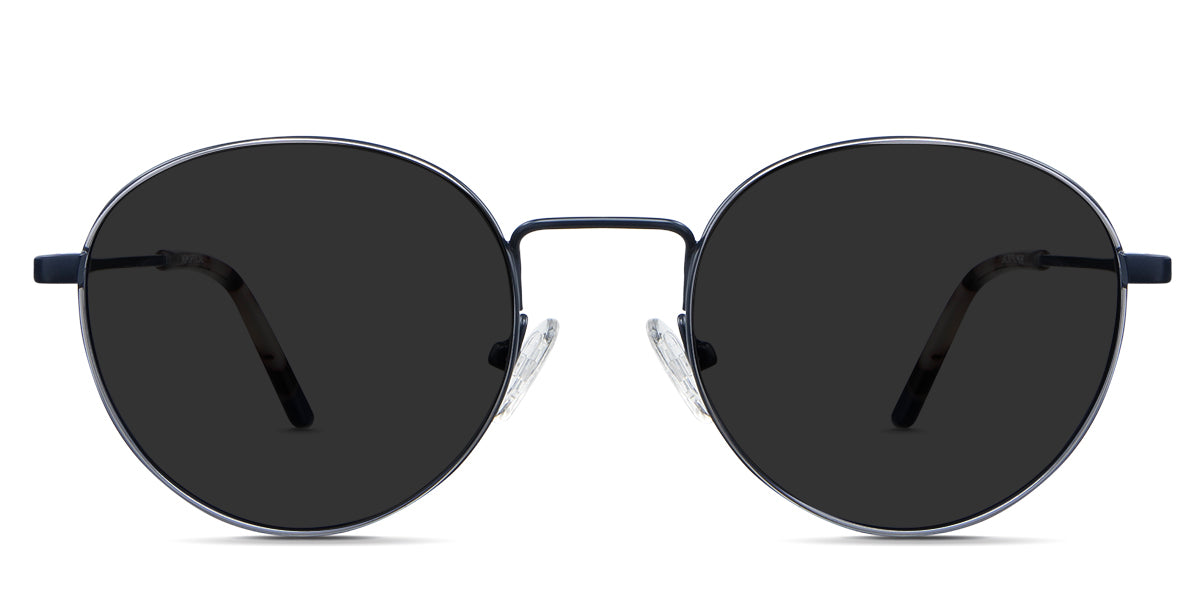 Adler Black Sunglasses Standard  Solid in the Capri variant - it's a round frame with a high nose bridge and a slim metal arm and acetate tips.
