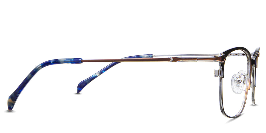 Kira Eyeglasses in the okapi variant - have a metal arm and acetate blue temple tips.