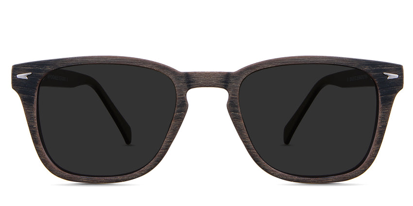 Senecio black tinted Standard Solid sunglasses in the elmwood variant - it's a square full-rimmed frame with a wooden pattern and a metal emboss in the end piece.